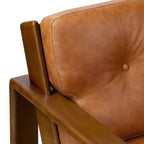 Fauteuil de salon moderne en cuir couleur cognac avec dossier capitonné