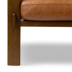 Fauteuil de salon moderne en cuir couleur cognac avec dossier capitonné